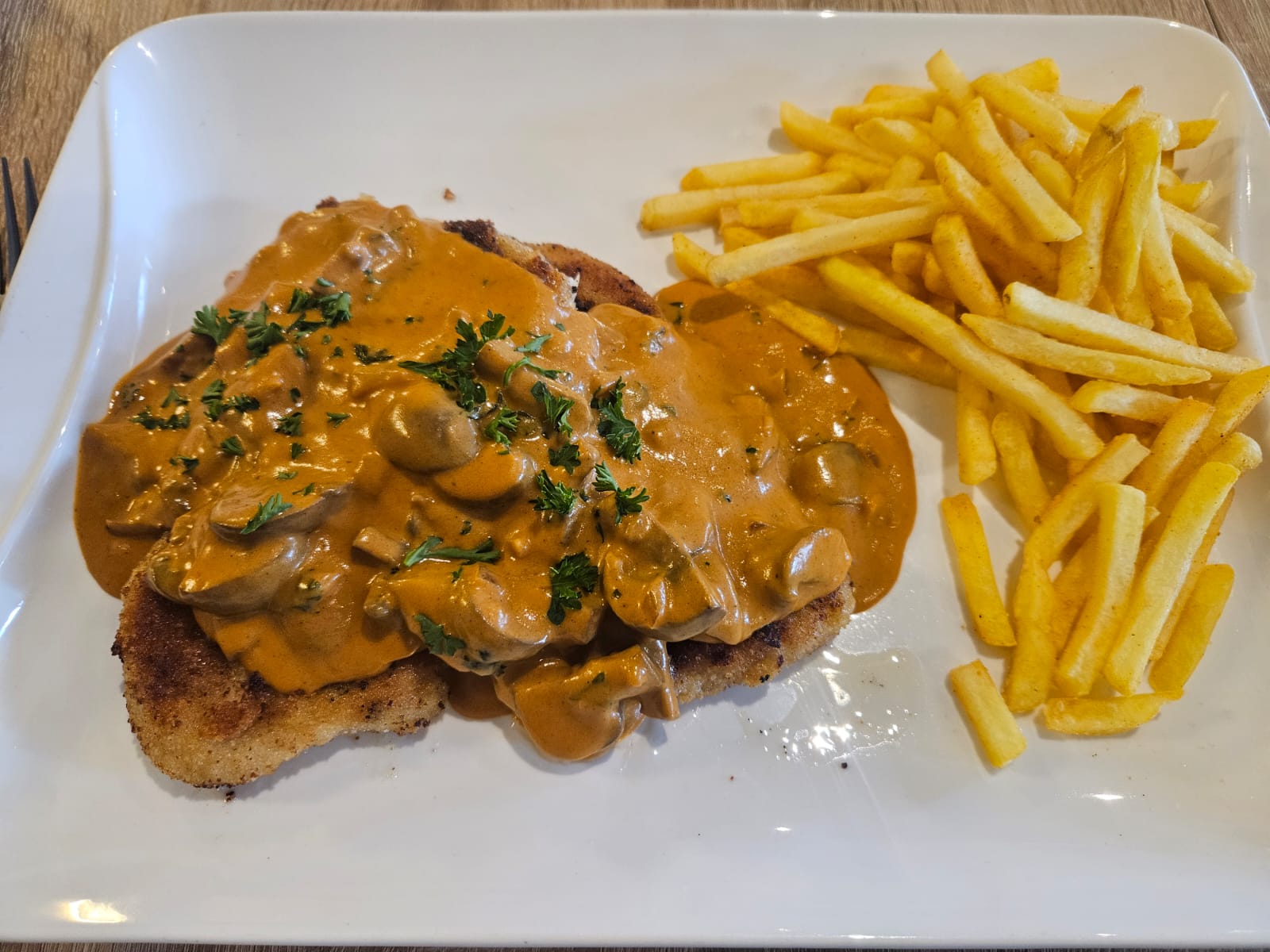 Schnitzel mit Champignonsoße und Pommes